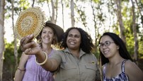 Tourists and tour guide looking at handmade crafts