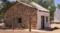 image of old building facing wall is stone and front wall is whitewashed