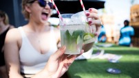 Woman with a drink and a hand with a drink in forefront