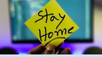 image of hand holding post it note with text Stay Home