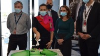 image of large green cake shaped like australia with spokespeople behind