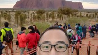 image of Takahiro with people and Uluru in background