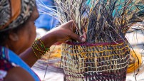 An Aboriginal woman weaves a basket for demonstration in Katherine