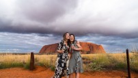 image of women hugging in from of Uluru