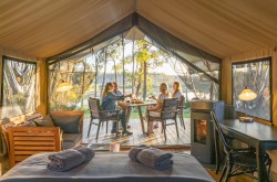 People eating breakfast outside their luxury tent