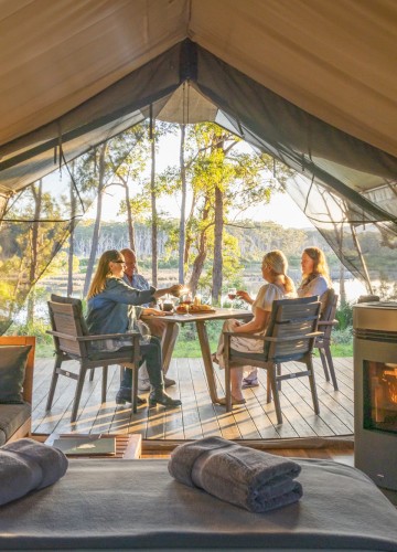 People eating breakfast outside their luxury tent