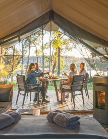 People eating breakfast outside their luxury tent