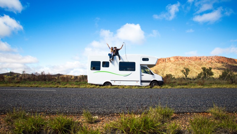 Couple sitting on top of campervan
