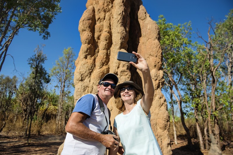 Couple taking a selfie in front of a termite mound