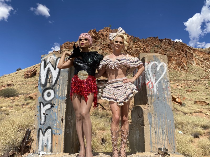 drag queens pictured between two concrete blocks with ranges behind them