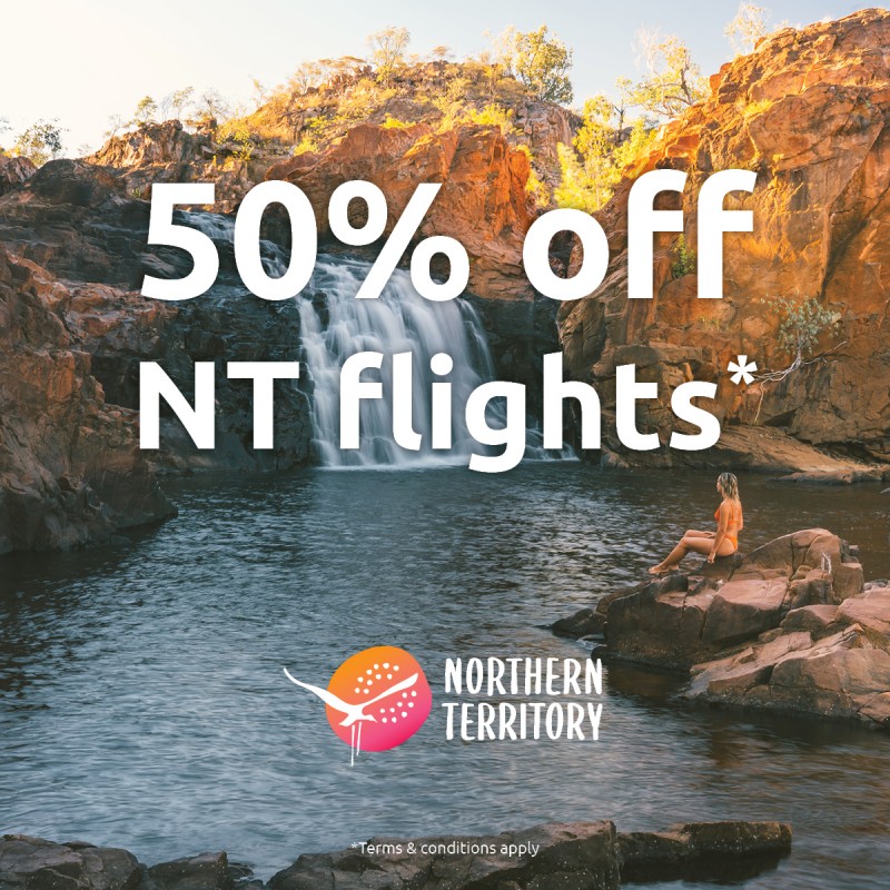 text of 50% off NT flights on top of image of waterfall with woman on rock