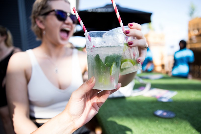 Woman with a drink and a hand with a drink in forefront