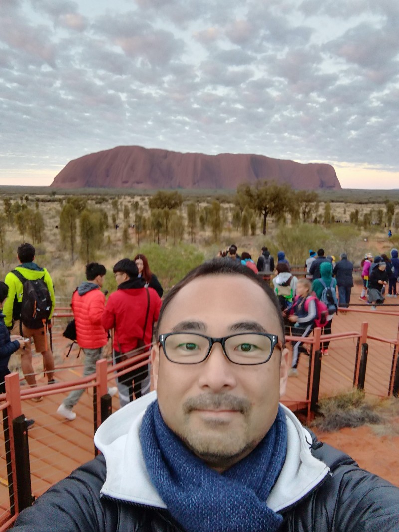 image of Takahiro with people and Uluru in background