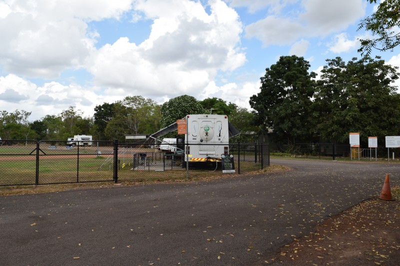 image of RV park with fence and bus parked