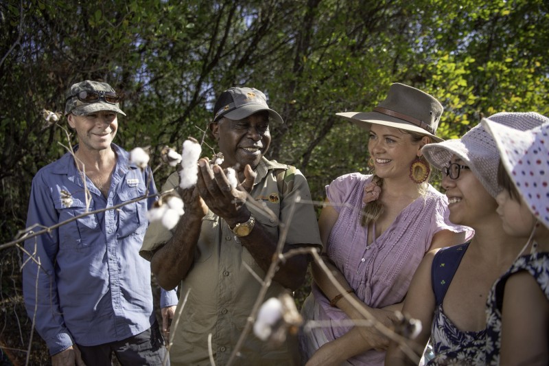 Aboriginal tour guide showing local flora to visitors in Kakadu National Park