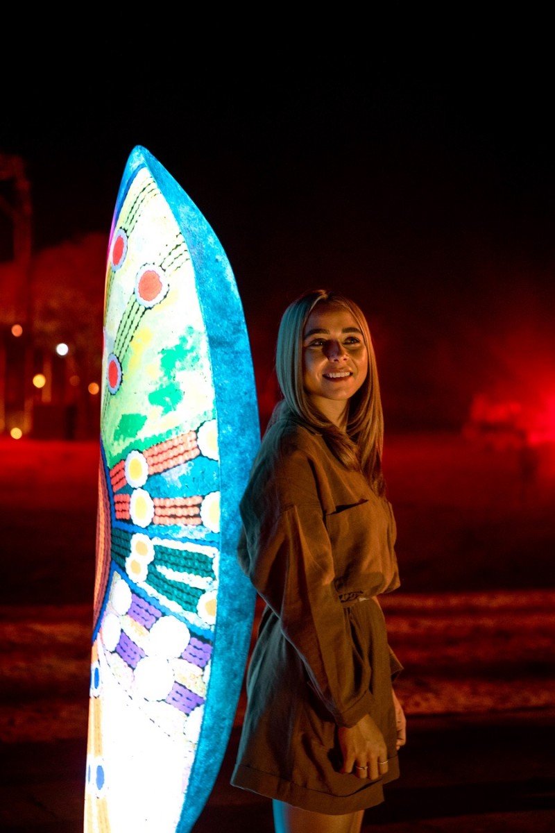 woman standing against a light installation