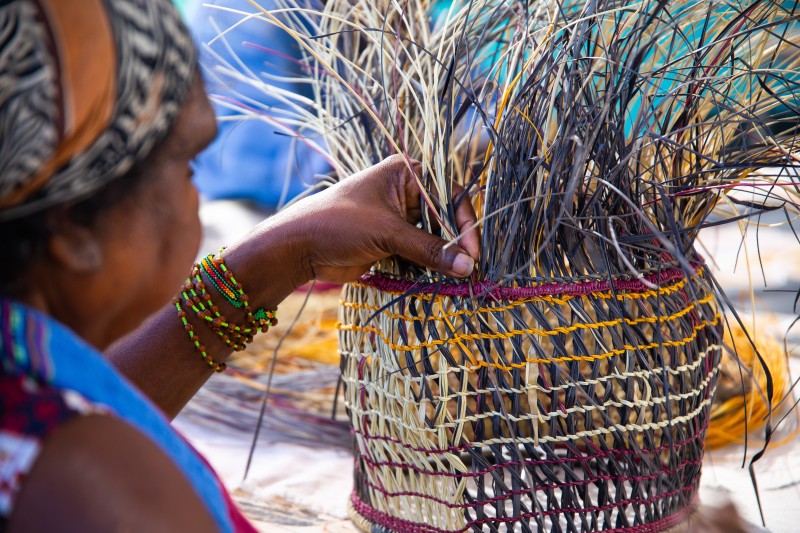 An Aboriginal woman weaves a basket for demonstration in Katherine