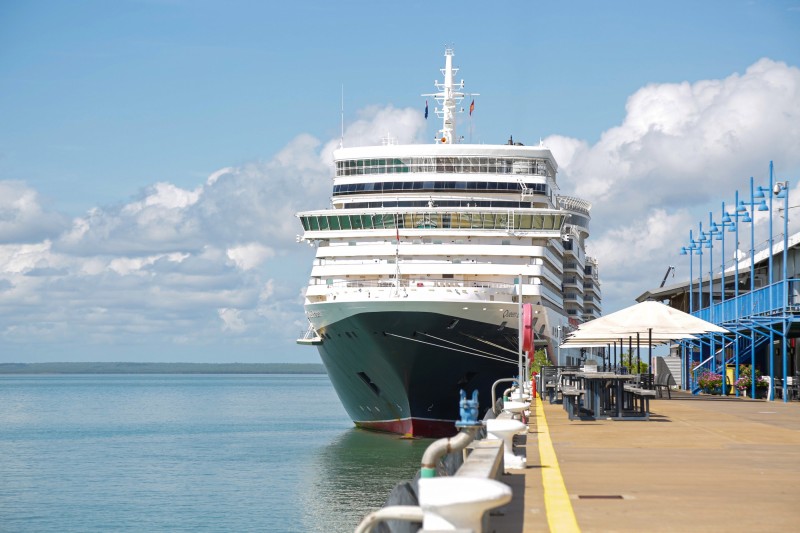 cruise ship docked at wharf with clouds behind